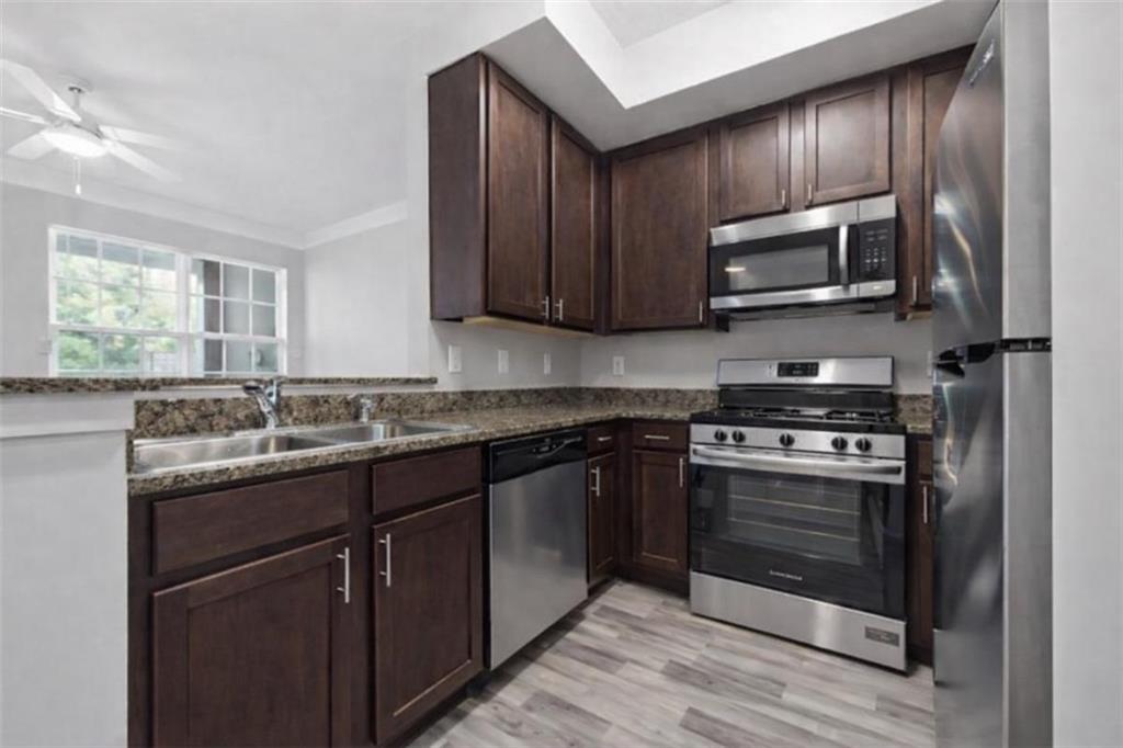 1752 Pryor Road Southwest, Unit 111 Atlanta, GA 30315 - Photo 6 of 20 a kitchen with stainless steel appliances granite countertop a stove microwave and sink
