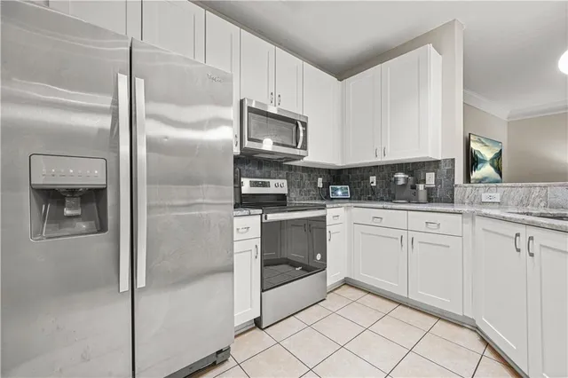 a kitchen with white cabinets and sink