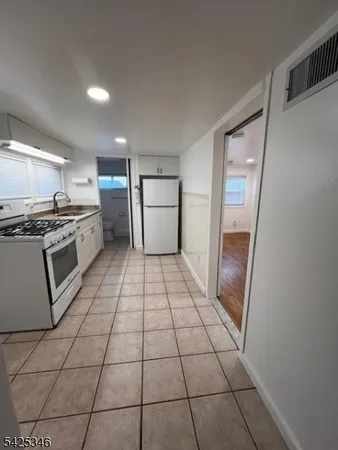 a kitchen with granite countertop a stove a sink and a refrigerator