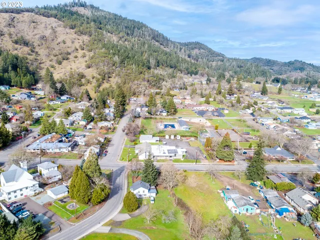 an aerial view of a residential houses with outdoor space and swimming pool