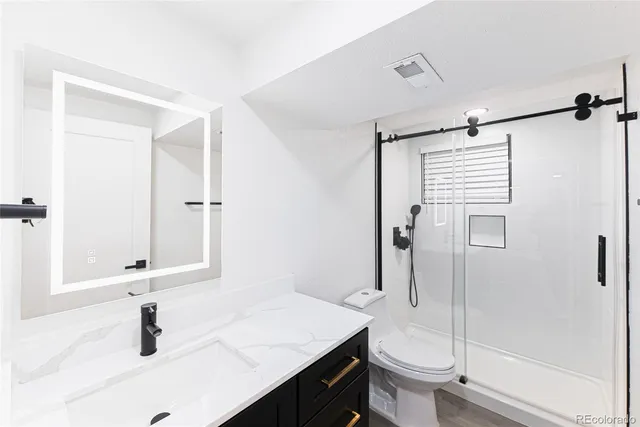 a bathroom with a sink a toilet and shower