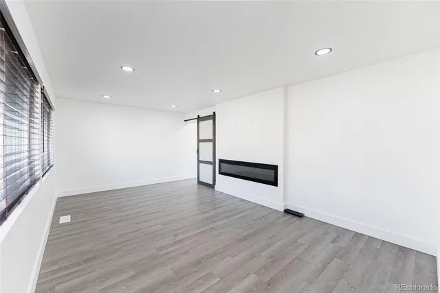 a view of an empty room with wooden floor