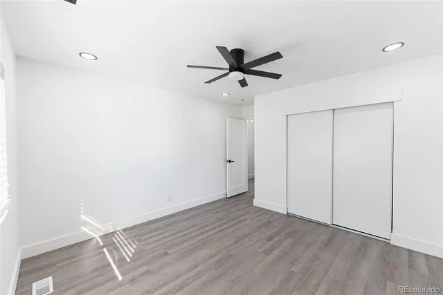 a view of a room with wooden floor and ceiling fan