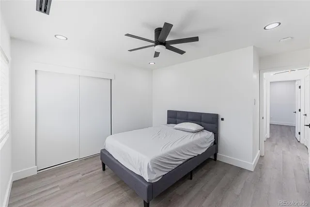 a bedroom with a bed and a ceiling fan