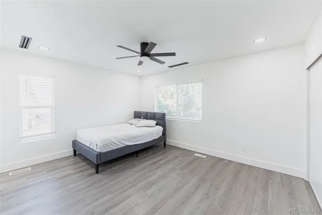 a spacious bedroom with a bed a window and a chandelier