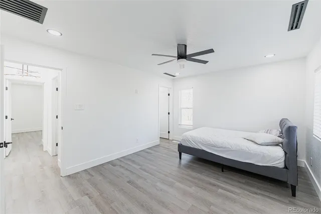 a bedroom with a bed and a ceiling fan