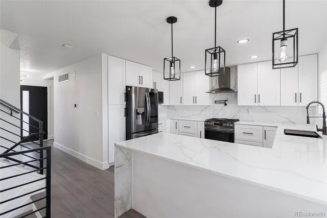 a kitchen with stainless steel appliances a sink a stove a refrigerator and cabinets