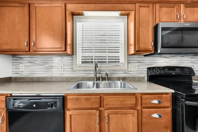 a kitchen with granite countertop cabinets stainless steel appliances and a sink