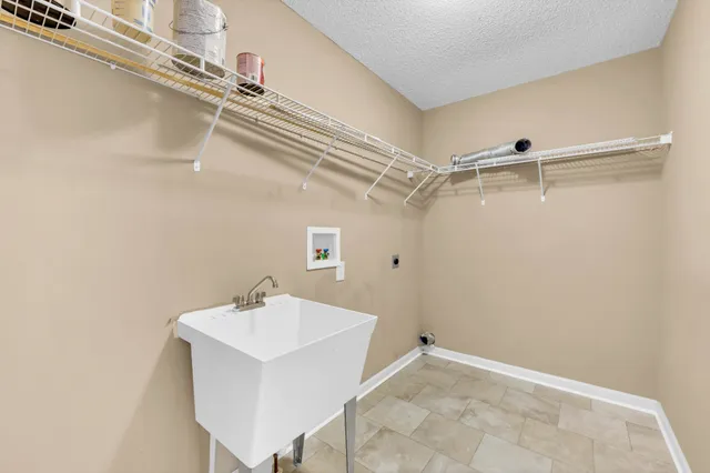 a view of a big room with windows and chandelier fan