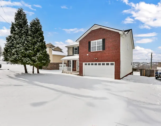 a view of a house with a yard and garage