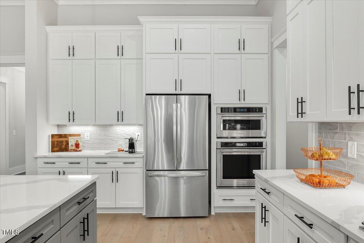 3812 Stoneridge Drive Raleigh, NC 27612 - Photo 13 of 46 a kitchen with white cabinets and white appliances