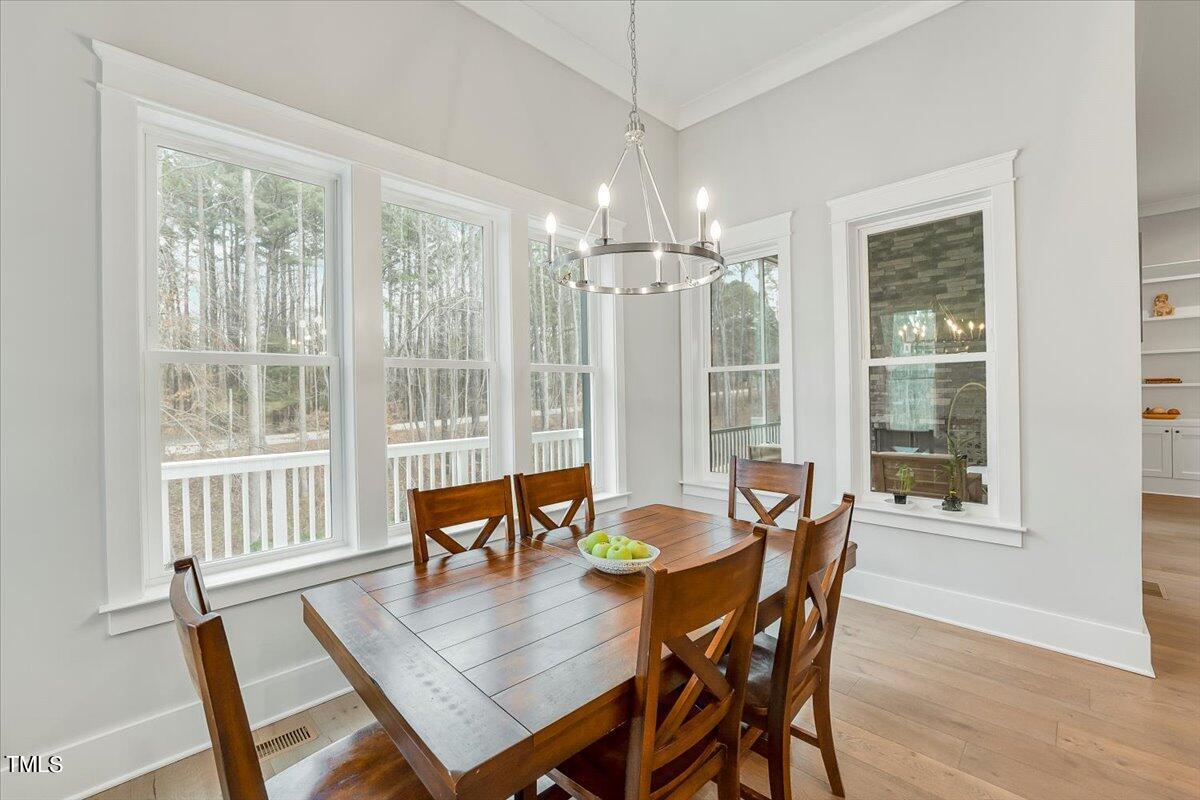 3812 Stoneridge Drive Raleigh, NC 27612 - Photo 15 of 46 a view of a dining room with furniture window and wooden floor