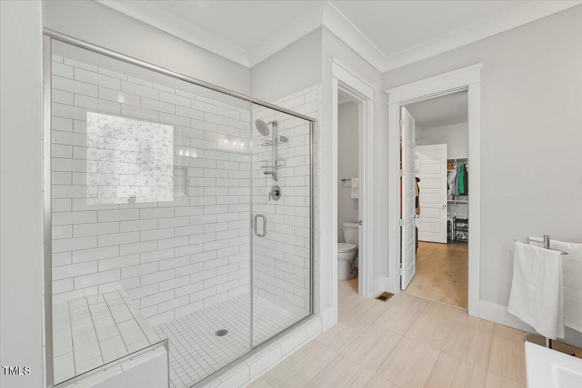 3812 Stoneridge Drive Raleigh, NC 27612 - Photo 19 of 46 a bathroom with a shower and a glass door