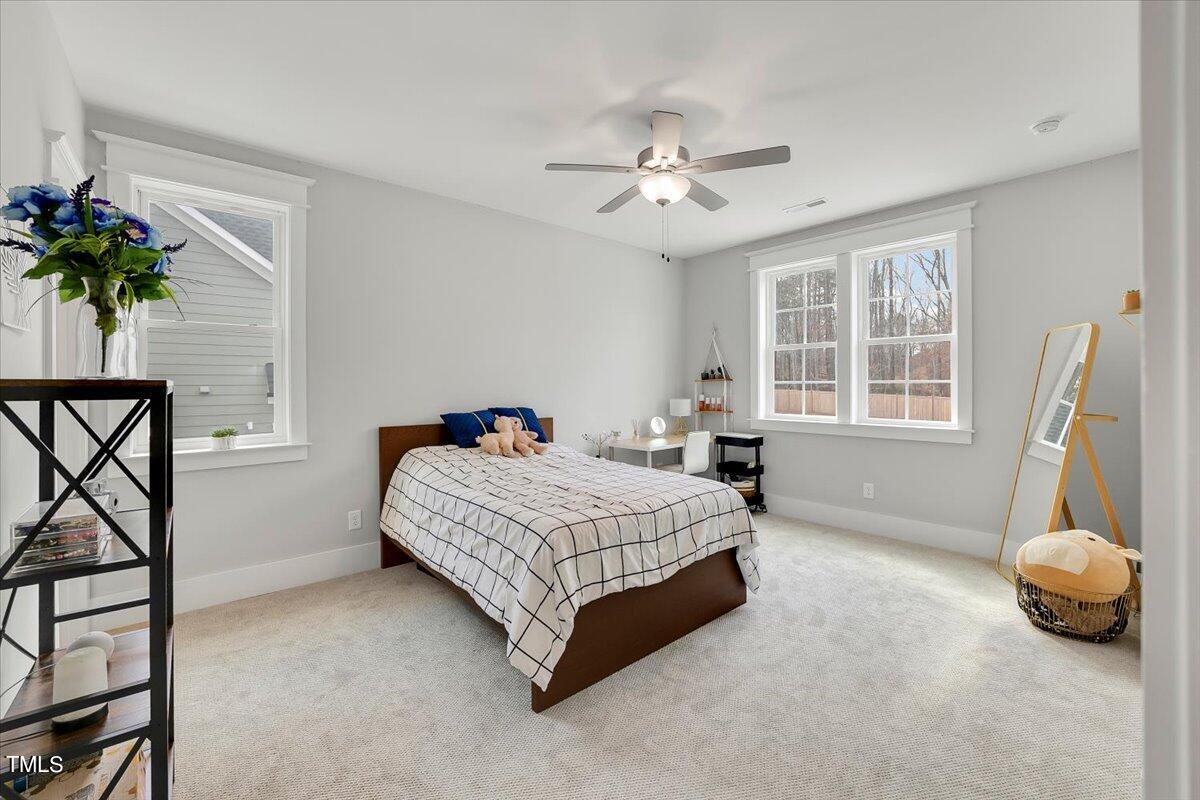 3812 Stoneridge Drive Raleigh, NC 27612 - Photo 28 of 46 a spacious bedroom with a bed and a chandelier