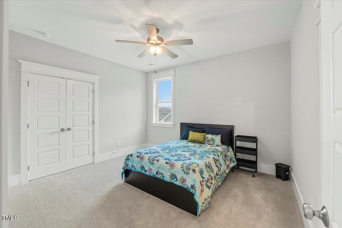 3812 Stoneridge Drive Raleigh, NC 27612 - Photo 30 of 46 a bedroom with a bed and a chandelier fan
