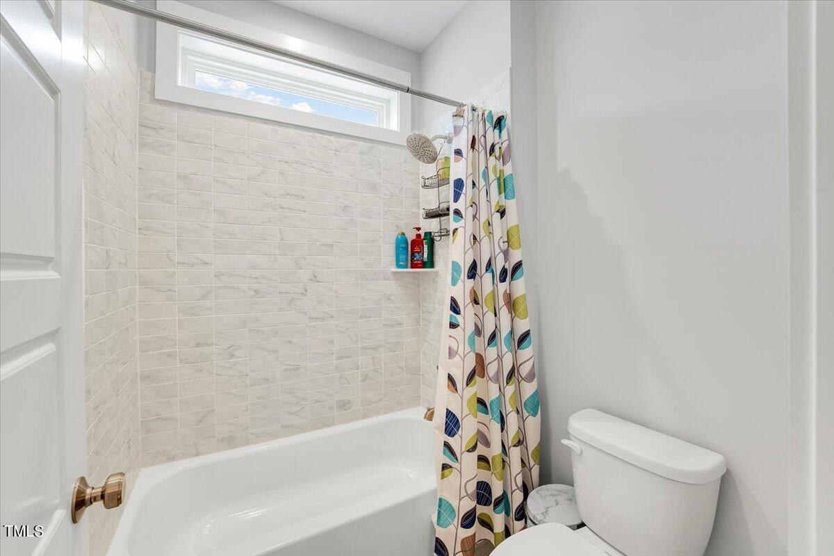 3812 Stoneridge Drive Raleigh, NC 27612 - Photo 32 of 46 a bathroom with a toilet and a shower curtain
