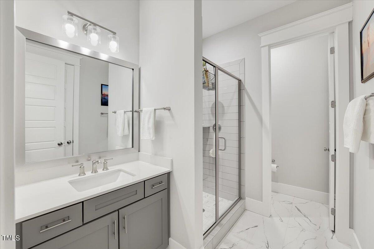 3812 Stoneridge Drive Raleigh, NC 27612 - Photo 41 of 46 a bathroom with a shower sink and mirror