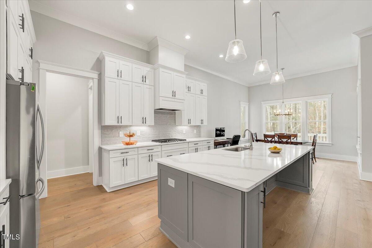 3812 Stoneridge Drive Raleigh, NC 27612 - Photo 9 of 46 a kitchen with a sink a stove a refrigerator and a center island