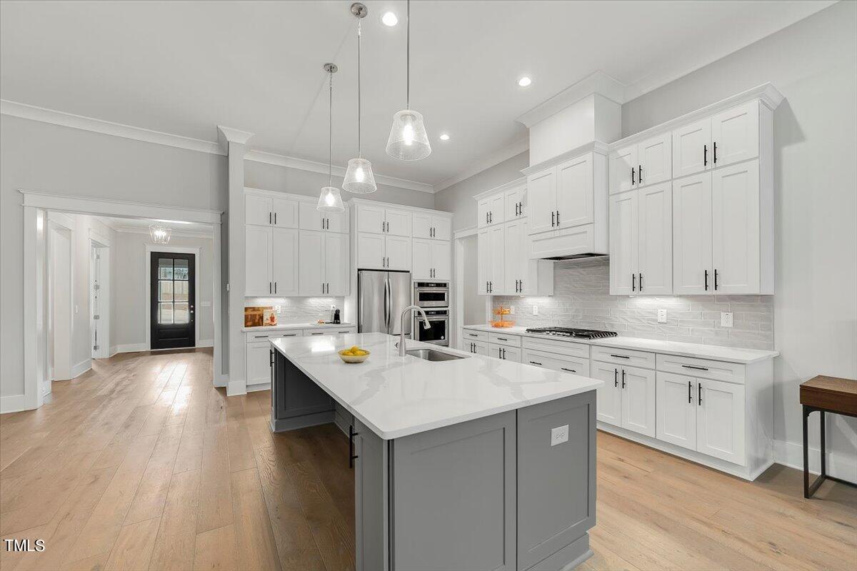 3812 Stoneridge Drive Raleigh, NC 27612 - Photo 10 of 46 a kitchen with a sink a center island stainless steel appliances and cabinets