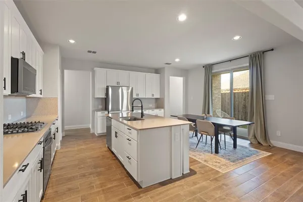 a kitchen with stainless steel appliances a sink stove and refrigerator