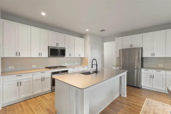 a kitchen with a table chairs refrigerator and cabinets