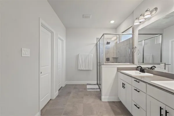 a bathroom with a double vanity sink a mirror and shower