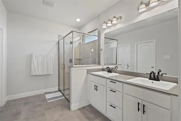 a bathroom with a granite countertop sink a mirror and shower