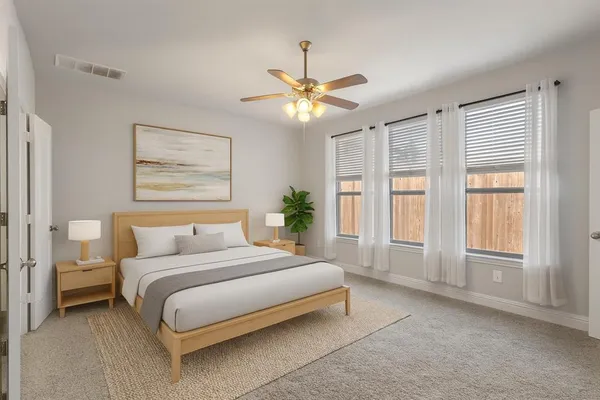 a bedroom with a large bed and a chandelier fan