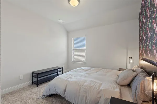 a bedroom with a large bed and a window