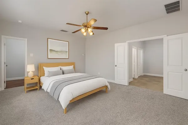 a spacious bedroom with a bed and a chandelier