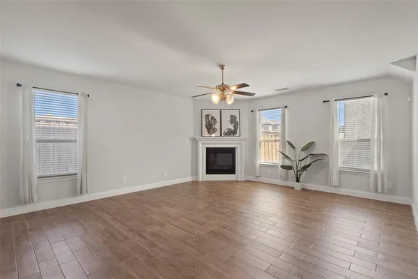 a view of a livingroom with a fireplace a chandelier and wooden floor