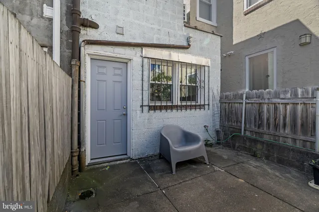 a view of a house with a barbeque and wooden fence
