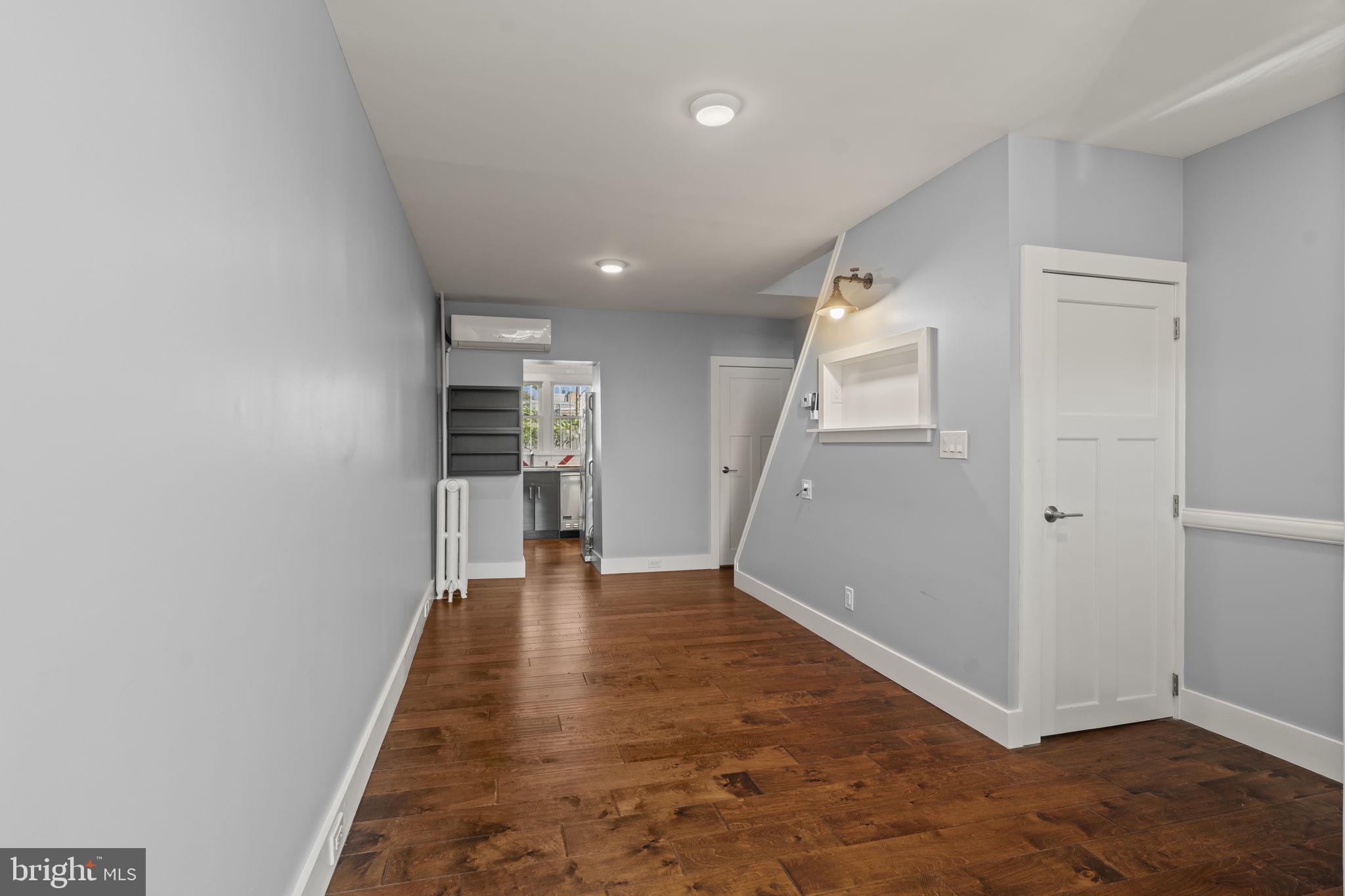2173 East Hagert Street Philadelphia, PA 19125 - Photo 6 of 23 an empty room with wooden floor and a kitchen