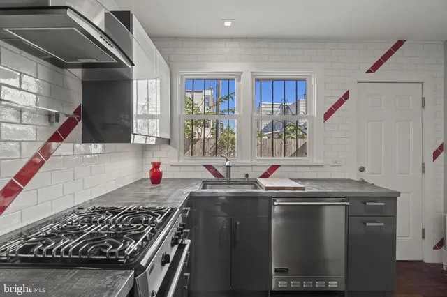 a kitchen with stainless steel appliances granite countertop a sink stove and cabinets