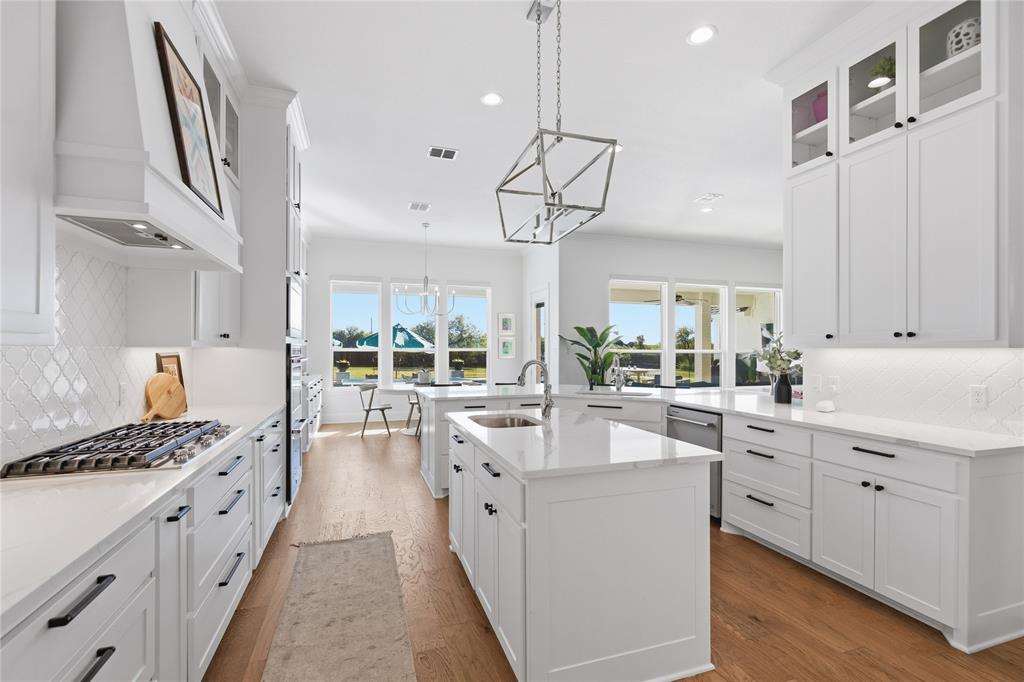 7754 Barber Rnch Road Fort Worth, TX 76126 - Photo 15 of 38 a large white kitchen with kitchen island granite countertop lots of white stainless steel appliances and white cabinets