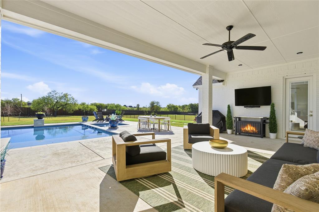 7754 Barber Rnch Road Fort Worth, TX 76126 - Photo 34 of 38 a living room with patio furniture and a flat screen tv