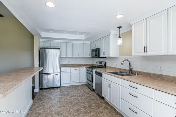 a kitchen with stainless steel appliances granite countertop a refrigerator sink and stove