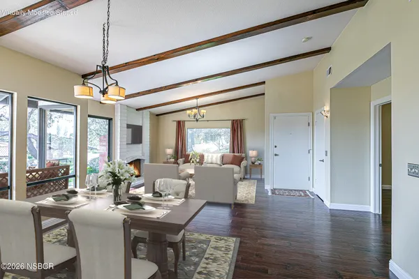 a view of a dining room and livingroom with furniture wooden floor a chandelier