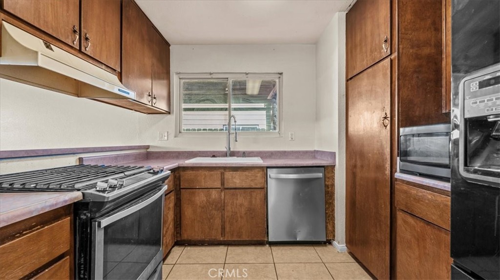 25607 Ash Road Barstow, CA 92311 - Photo 11 of 36 a kitchen with a stove sink and refrigerator