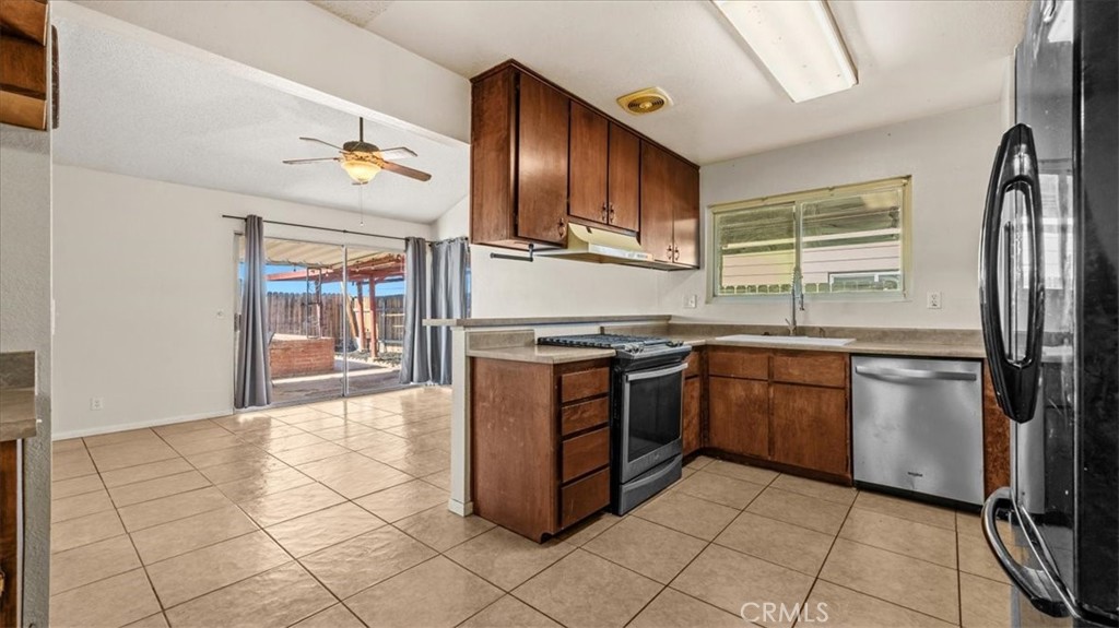 25607 Ash Road Barstow, CA 92311 - Photo 12 of 36 a kitchen with stainless steel appliances granite countertop a stove a sink and a refrigerator