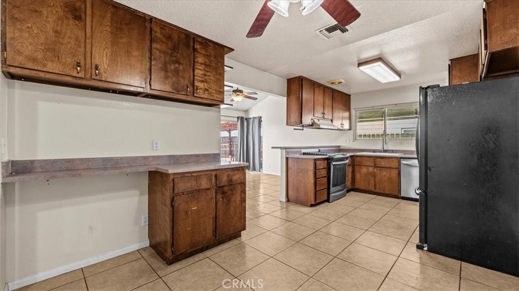 25607 Ash Road Barstow, CA 92311 - Photo 14 of 36 a kitchen with stainless steel appliances granite countertop a stove and a refrigerator