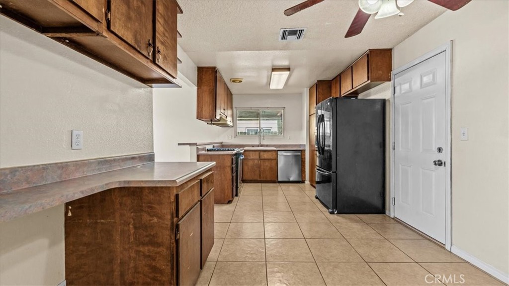 25607 Ash Road Barstow, CA 92311 - Photo 15 of 36 a kitchen with stainless steel appliances granite countertop a refrigerator and a sink
