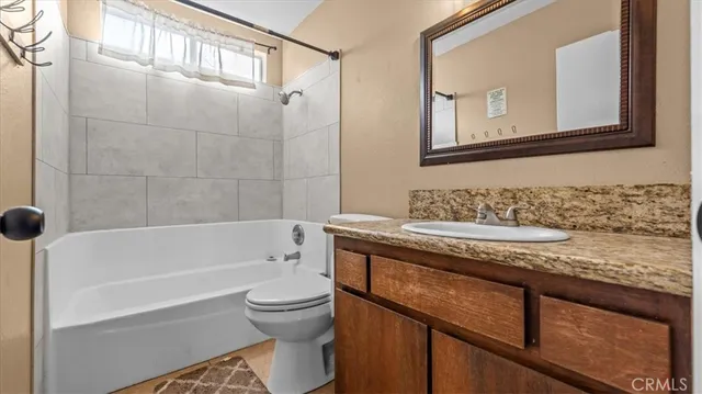 a bathroom with a granite countertop sink a toilet and bathtub