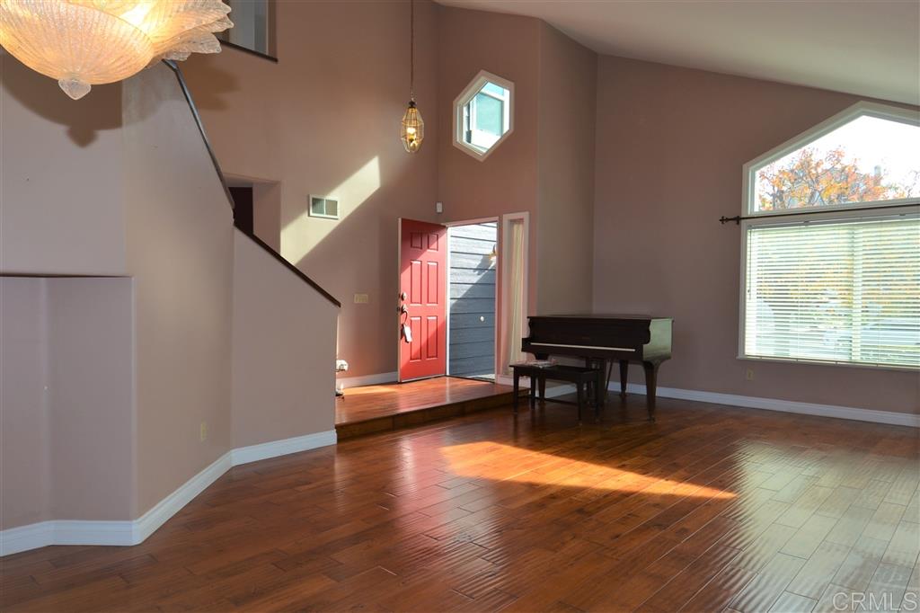 5050 Frazee Road Oceanside, CA 92057 - Photo 2 of 25 Towering Vaulted Ceilings and high transom windows flood the home with Natural Light. The gorgeous hard wood floors give a warm inviting coziness that defy the Spacious Interior.