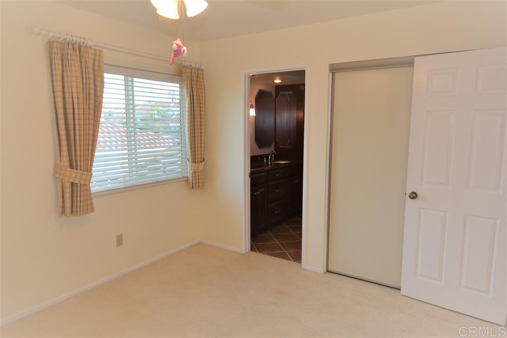 5050 Frazee Road Oceanside, CA 92057 - Photo 17 of 25 Here we see Guest Bedroom number two with it's decorator fan, double closet, private access to the Jack and Jill bath and notice the window coverings. Throughout the home you will find new thermo pane windows elegantly treated with wood look blinds