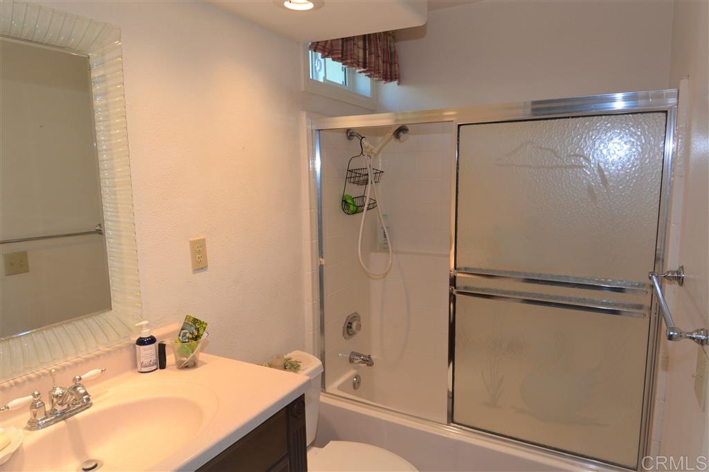 5050 Frazee Road Oceanside, CA 92057 - Photo 21 of 25 The ground floor full bath serves as the powder room... through a hall door. It also provides an ensuite ground floor guest suite. Notice too the new vinyl thermo pane window for natural ventilation.