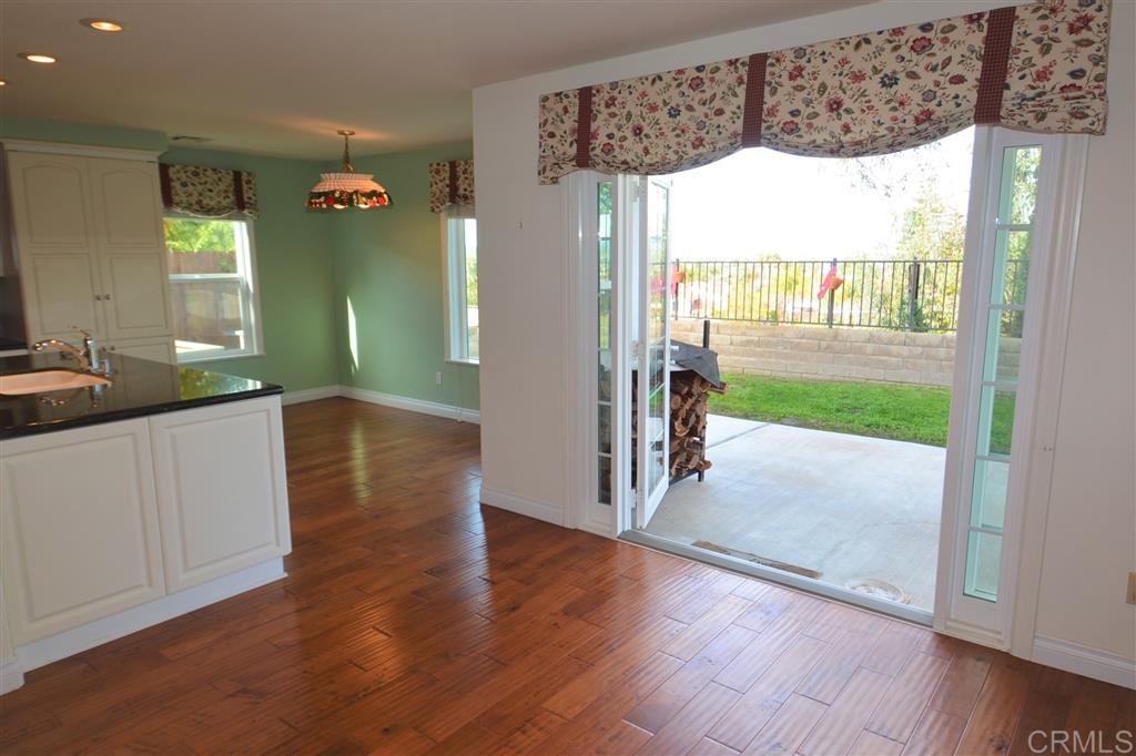 5050 Frazee Road Oceanside, CA 92057 - Photo 4 of 25 From the family room and Kitchen eating space there is this lovely double French door access to the covered patio, private yard, panoramic view and BBQ space of dreams.