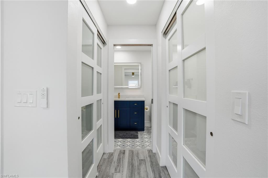 270 Dundee Road Fort Myers Beach, FL 33931 - Photo 25 of 48 Corridor with light wood-style flooring and a sink - Virtually Edited Image