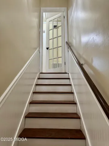 a view of an empty room with window and chandelier fan