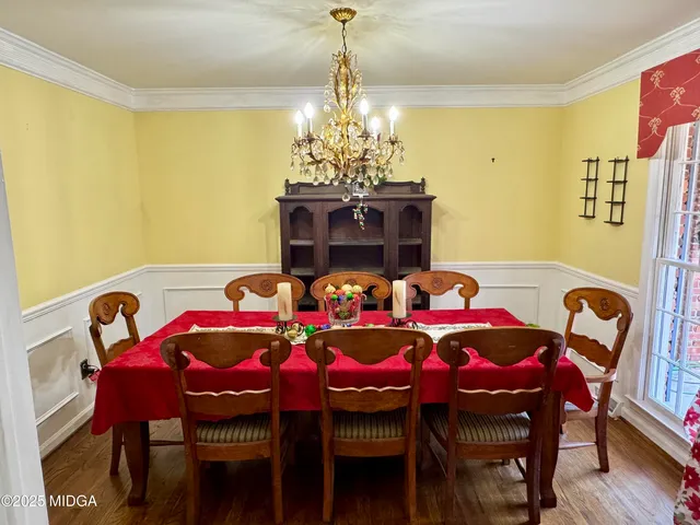 a kitchen with white cabinets a sink a stove a window and cabinetry